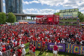 Audience outside. Coca-Cola Fan Zone booth and FIFA Fan Festival Toronto banner in the background