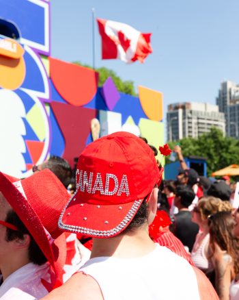 fan enjoying the FIFA Fan Festival, image of back of fan head wearing a red Canada logo ball cap
