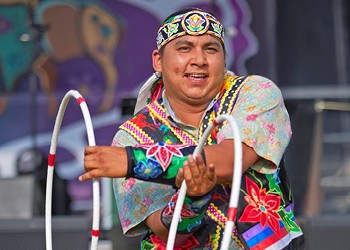 Close up of a hoop dancer with a stage in the background