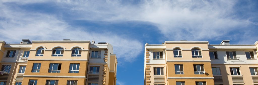 Tan coloured buildings against blue sky.