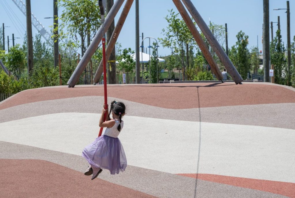 Little girl playing on cable line in Biidaasige Park.