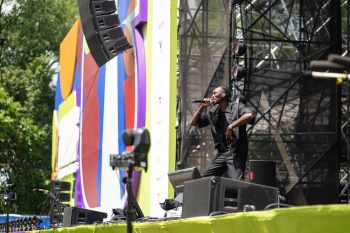 Person sings into microphone on outdoor stage