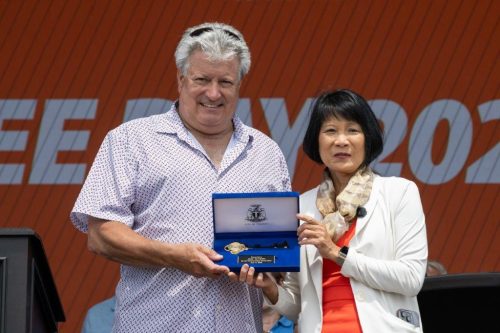 Two persons facing the camera, holding a velvet box between them