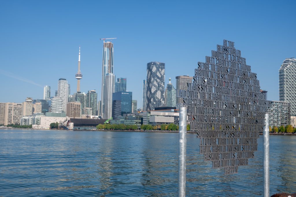 A metal sculpture feature words and phrases overlooking Toronto's inner Harbour