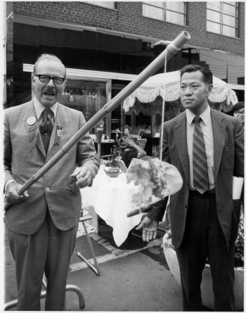 Image depicts two men at street festival