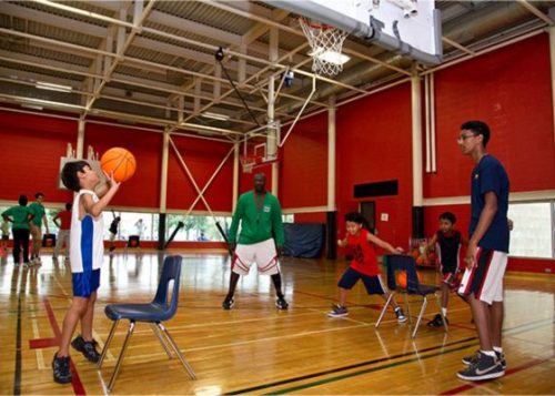 Young people playing basketball in an indoor facility in Toronto.
