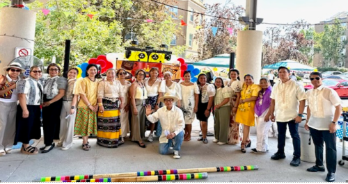 Filipino staff at Cummer Lodge proudly hosted a Filipino Fiesta in celebration of Philippine Independence Day and pose for a photo with cultural banners in the background.