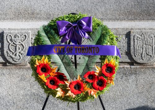 Wreath with a City of Toronto banner in front of a stone cenotaph