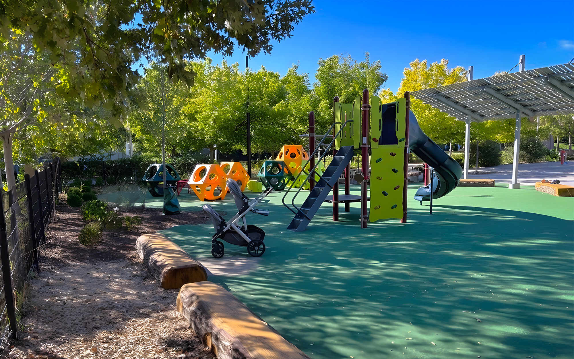 Close up of the new Wychwood Barns Park playground, showing a main play structure with two slides in front and play cubes at the back.