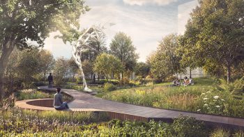 View inside the park along the boardwalk looking north with a direct view of the sculpture, a woman seated in the foreground and a group of friends on the sloped meadow to the right.